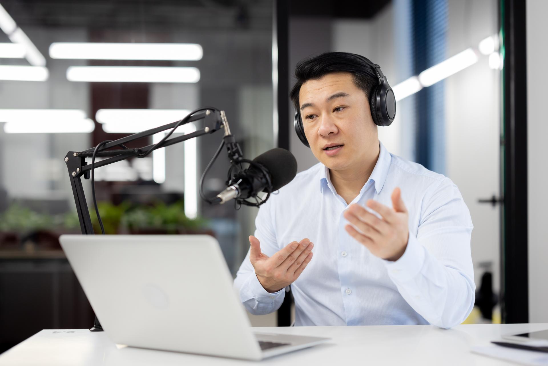 Professional asian male podcaster recording live show in studio